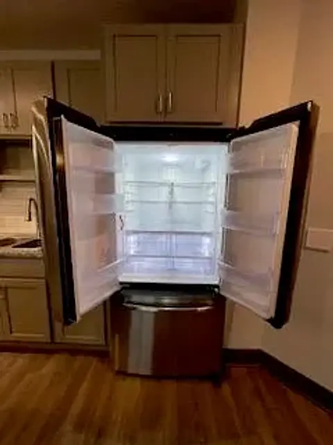 A French-door refrigerator, open, empty and clean