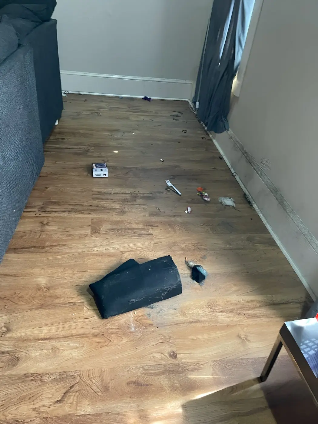 Before: Wood-look plank floor along a living-room wall